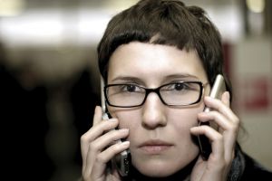 Persona hablando con dos móviles